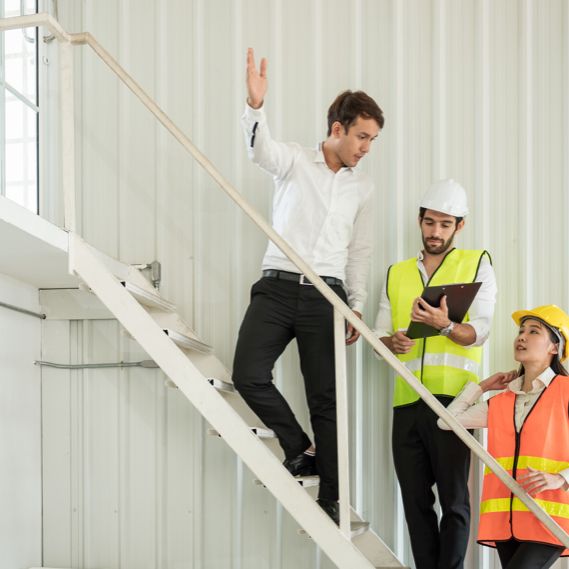 A manager speaks to members of the health and safety committee in a warehouse