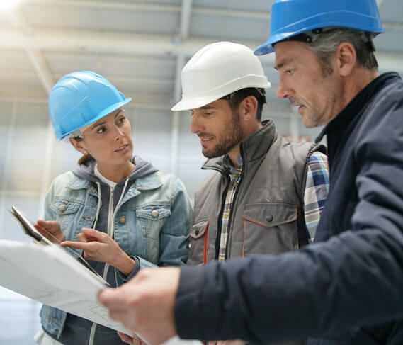 Three workers review plans