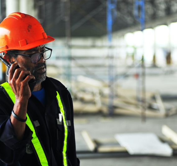 A construction worker speaks on a walkie talkie