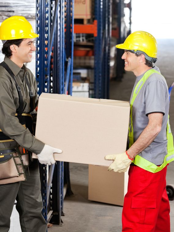 Two workers safely carry a heavy box together