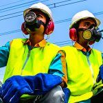 workers in hard hats, vests and respirators