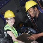 man and woman at work site going over safety checklist