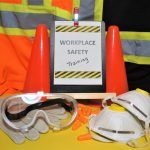 workplace safety training sign with safety equipment next to it