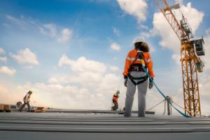 construction worker in safety harness near crane