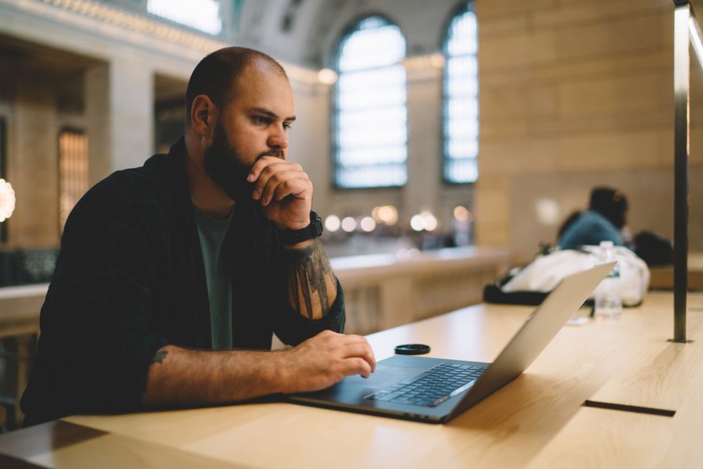 a man working online at a library
