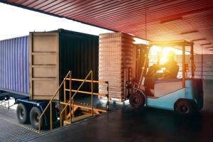 forklift at loading dock with trucks