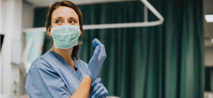 a woman wearing a mask and protective gloves