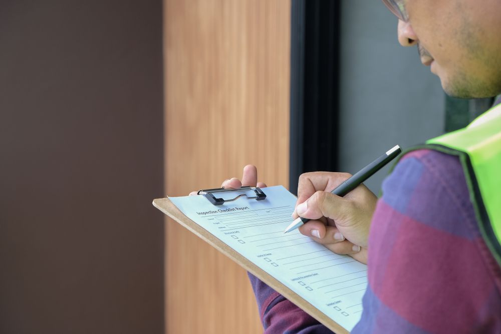 a safety consultant using a clipboard to take note of risks present in a workplace
