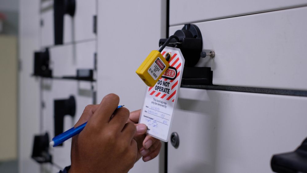 authorized worker writing on the lock out tag to complete safety procedure