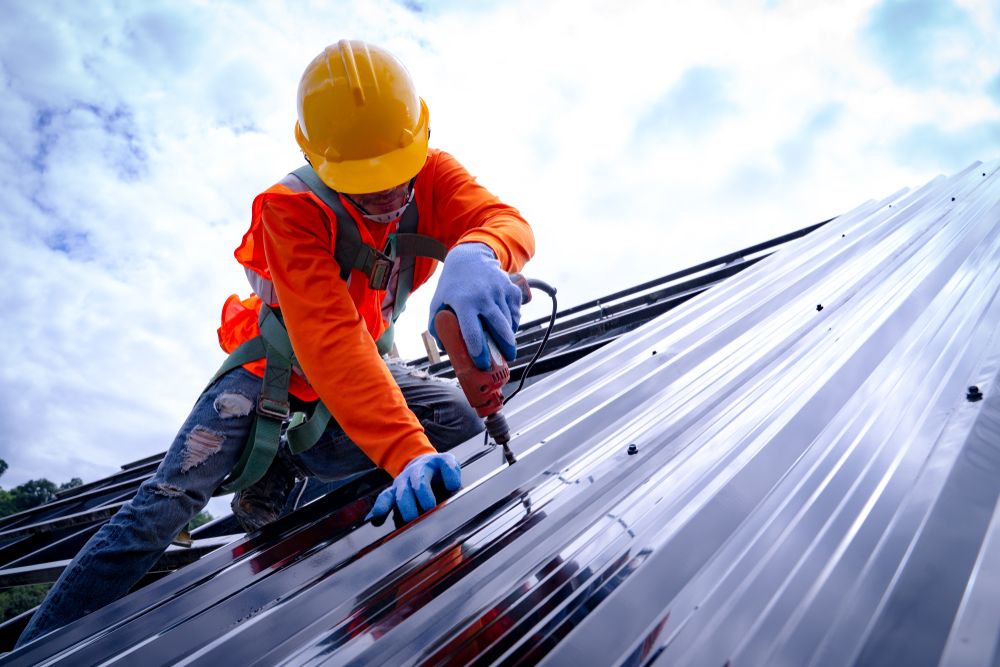 an employee working at heights installing metal sheeting
