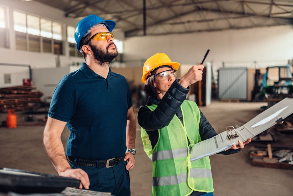 safety consultant working with a project manager to assess their workplace safety procedures