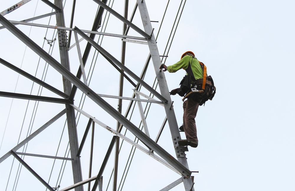 utility worker climbing a cell tower 