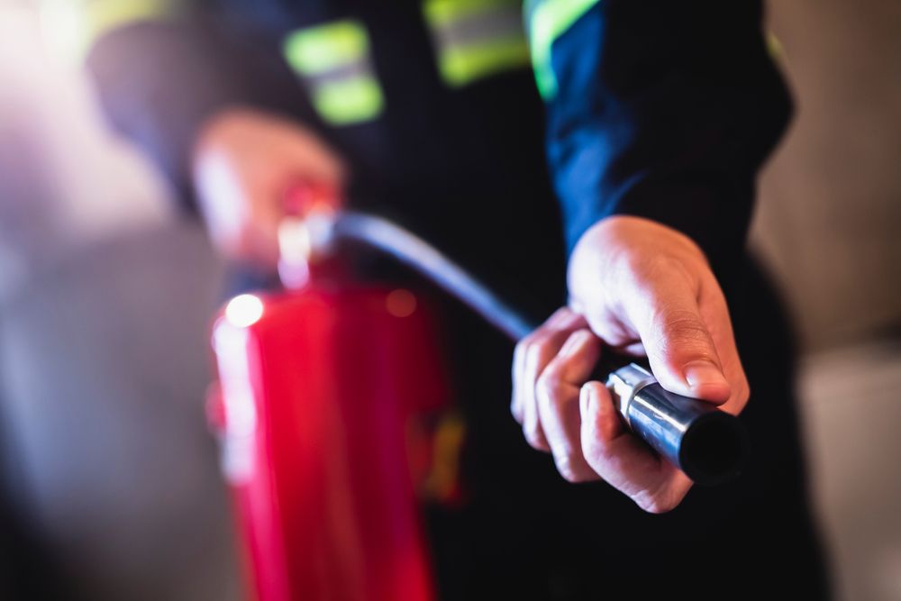 worker uses fire extinguisher