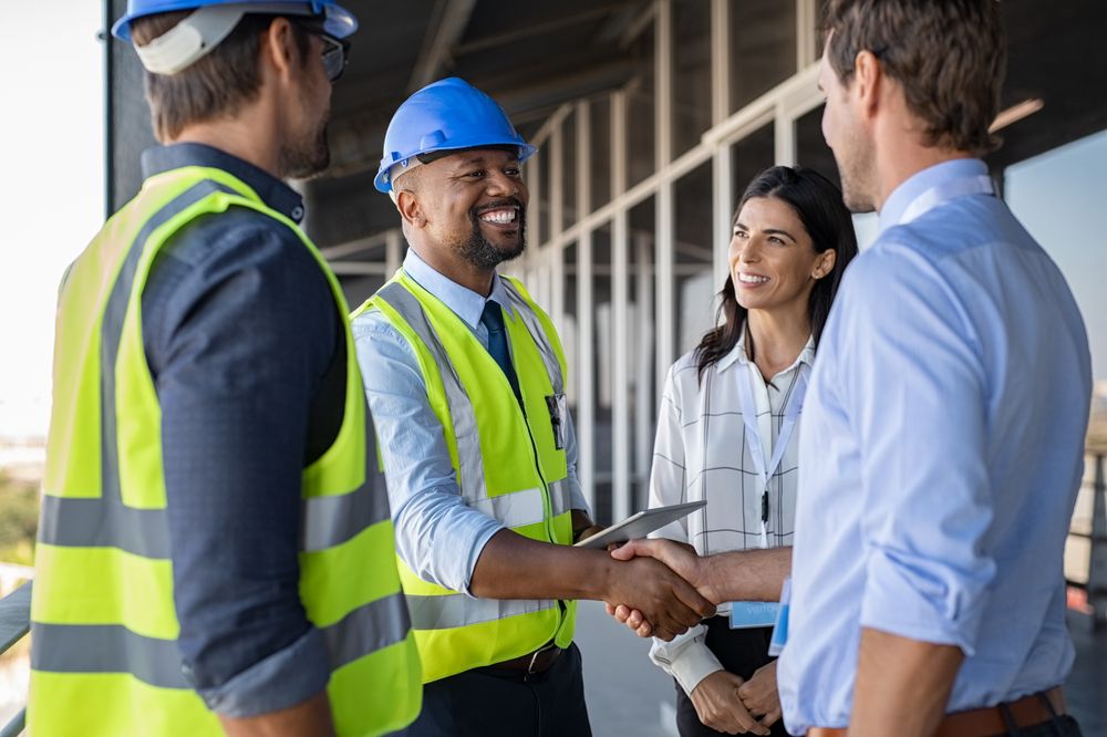 Smiling,Engineer,Shaking,Hands,At,Construction,Site,With,Happy,Architect. a construction manager meeting with a safety training representative