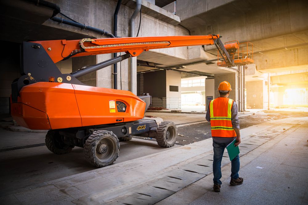 male engineer next to an aerial lift that is being inspected