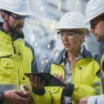 3 construction engineers working together on a device reviewing the safety program