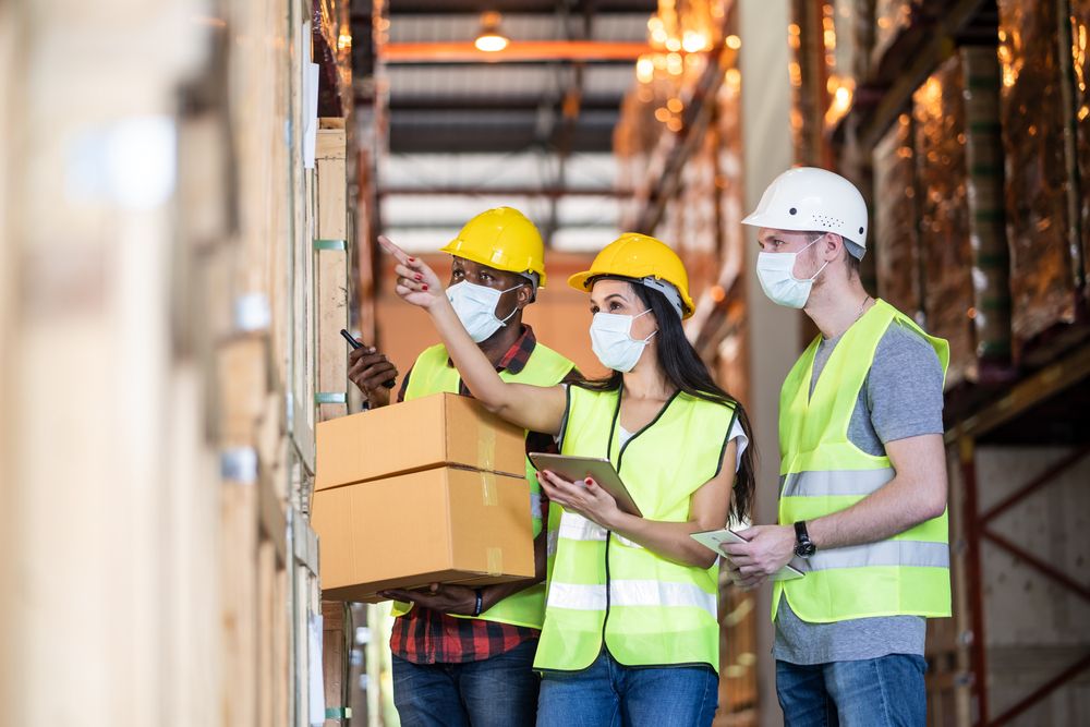 three warehouse workers discussing the risks of their tasks
