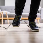 an office worker tripping over a cable that was placed in a high traffic area of the office