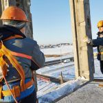 construction workers in safety gear harnesses