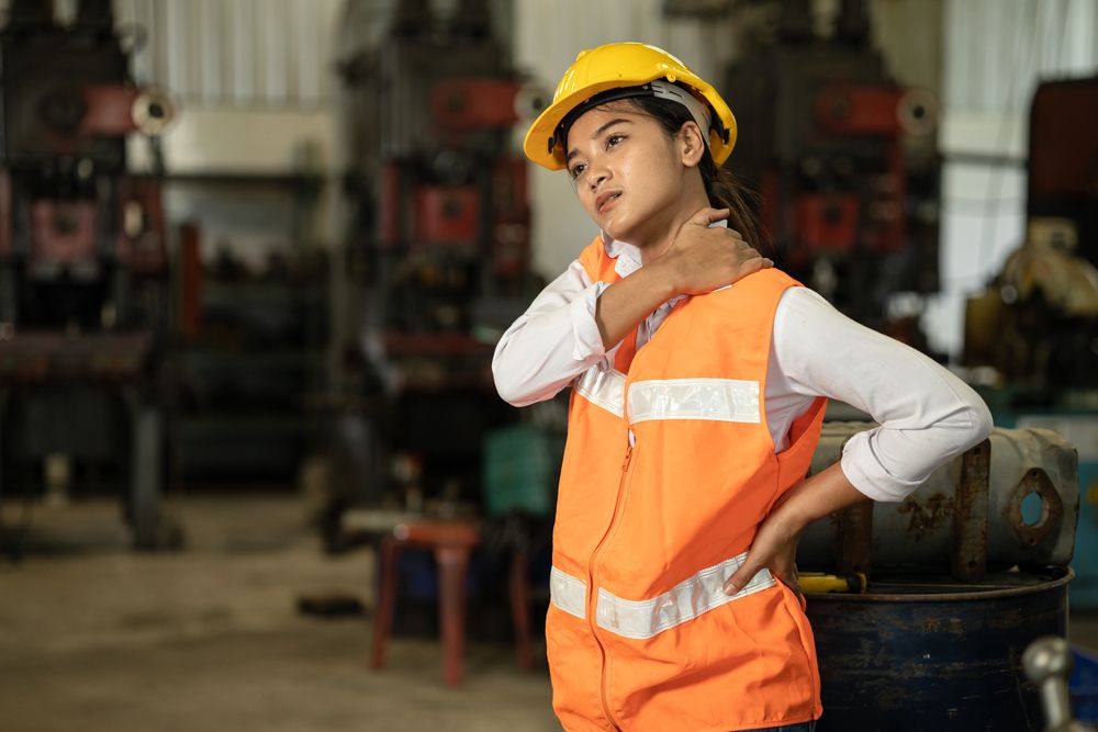 overworked warehouse employee suffering from ergonomic workplace hazards