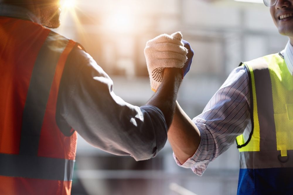 two construction workers congratulating each other on a job well done