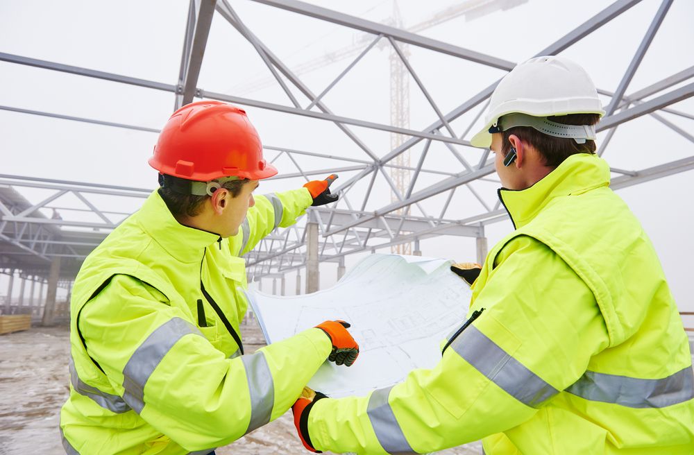 a safety leader wearing the proper equipment explaining best practices to a fellow employee