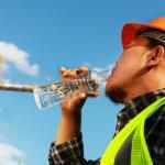 worker drinks water stays hydrated while outside in summer heat