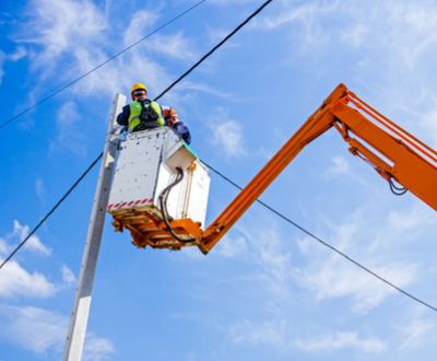 Workers in bucket lift work on wires safely
