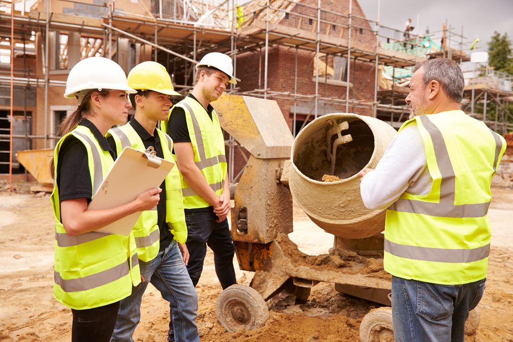 construction site workers being trained on cement mixer