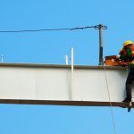 worker performing dangerous work at heights with proper fall arrest systems