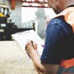 worker in vest going over safety checklist