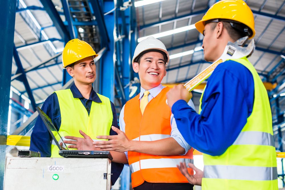 three employees a part of the health and safety team discussing plans for improving workplace safety