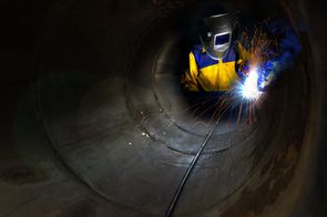 a worker welds inside of a confined space