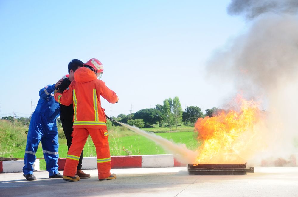 employee being trained on how to use a fire extinguisher