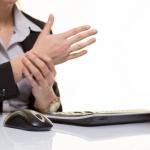 worker sits at computer with repetitive stress injury