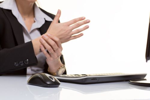 worker sits at computer with repetitive stress injury