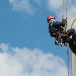 worker rappelling from heights using proper fall arrest equipment and systems