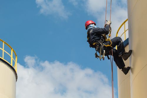 worker rappelling from heights using proper fall arrest equipment and systems