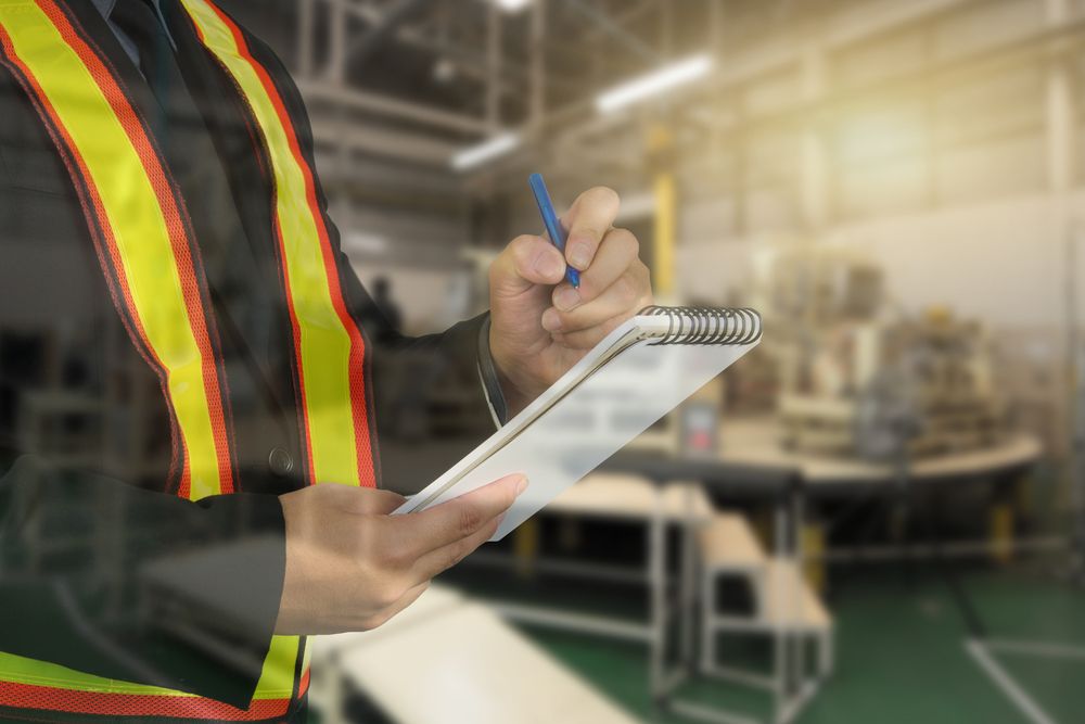 worker in safety vest assess hazards in workplace