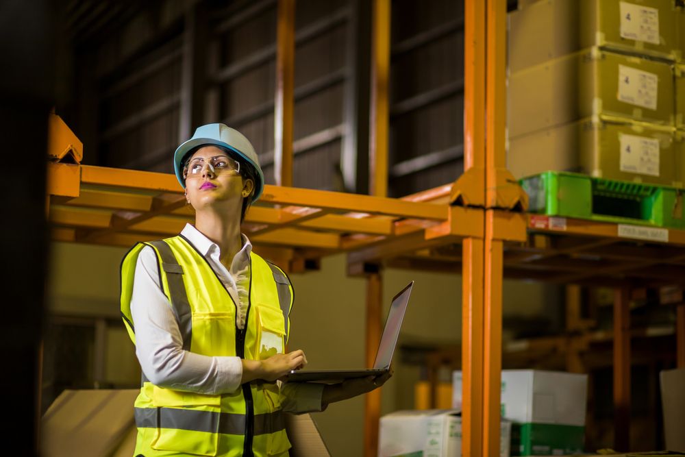 a safety auditor standing in a warehouse conducting a safety audit
