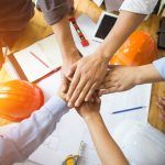 construction workers with their hands in a circle