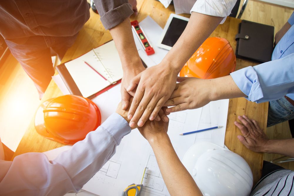 construction workers with their hands in a circle