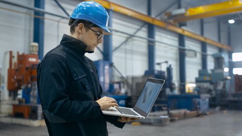 Factory Worker Using A Laptop - Safety Software Benefits