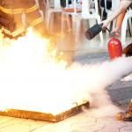 workers put out fire with extinguishers in fire drill