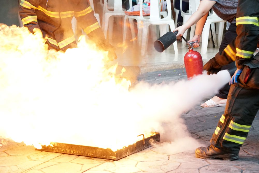 workers put out fire with extinguishers in fire drill