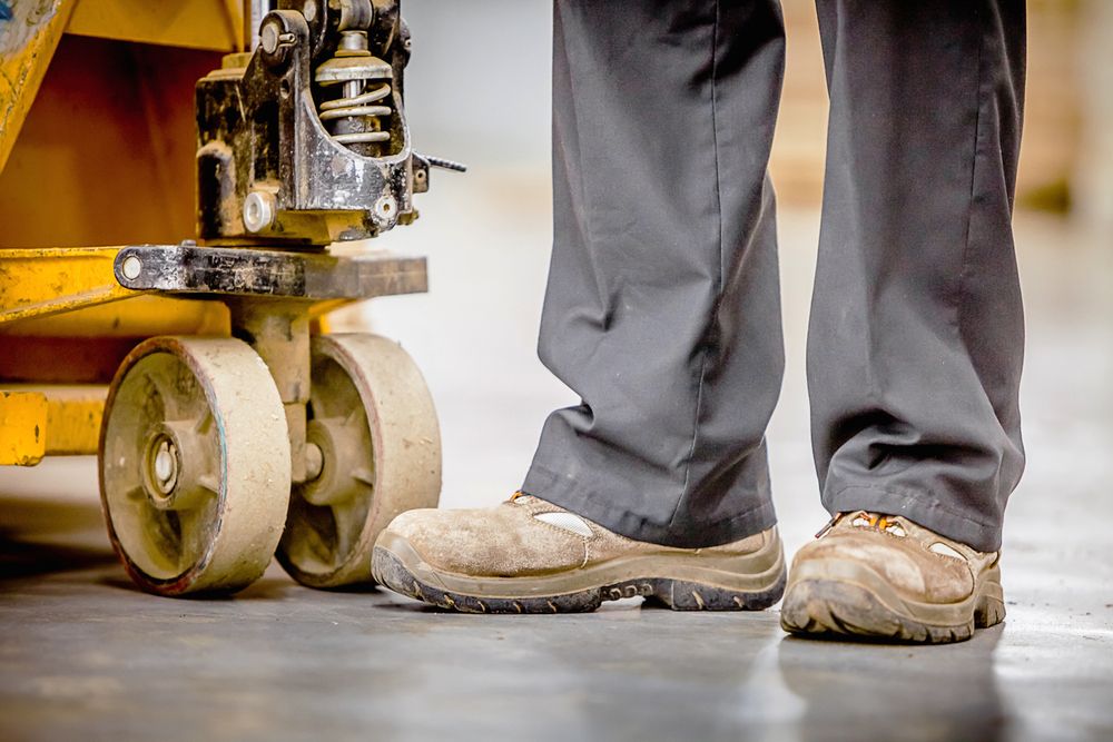 image of worker safety boots next to heavy machinery