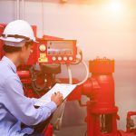 manager checks fire extinguishers in workplace