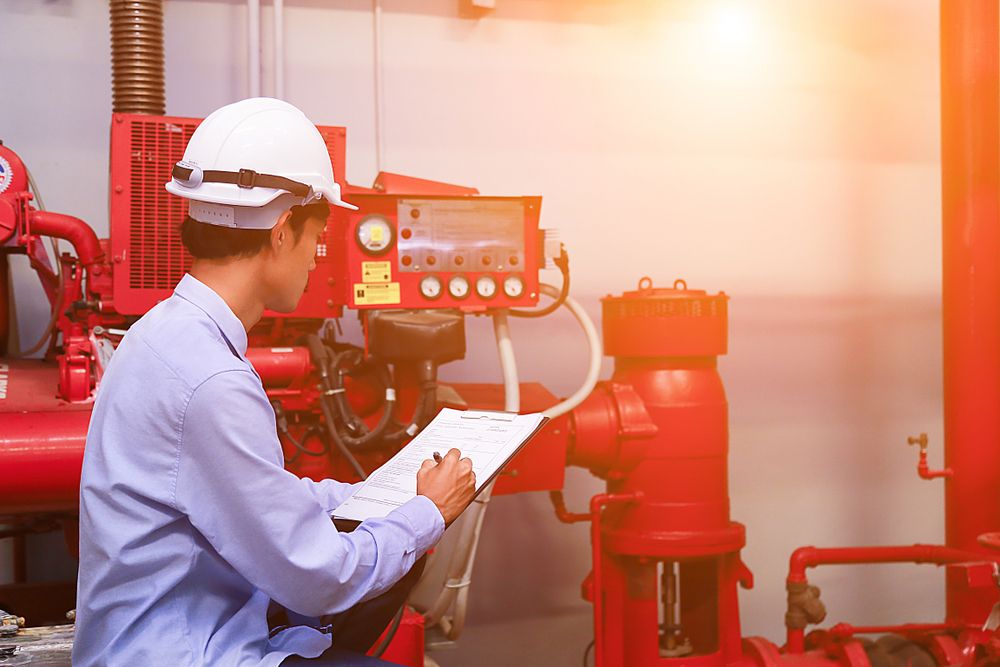 manager checks fire extinguishers in workplace