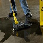 cleaning work floor with caution wet floor sign