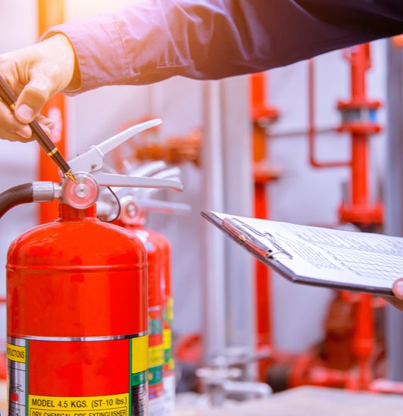A worker verifies the pressure on a fire extinguisher